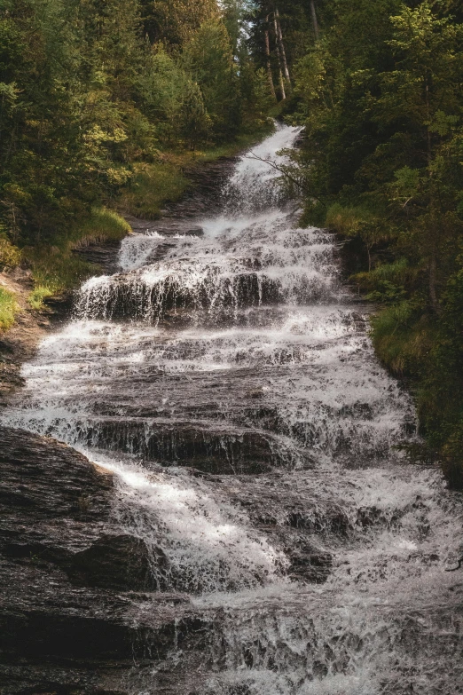 a group of people in the water near a waterfall