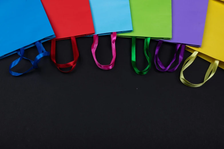 a row of folded colored notepads in different colors