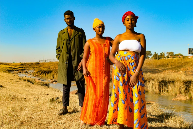 two women and two men standing in the dry grass