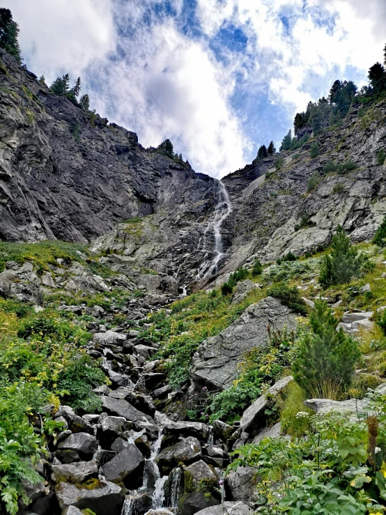 the water in the stream flows down the mountain side