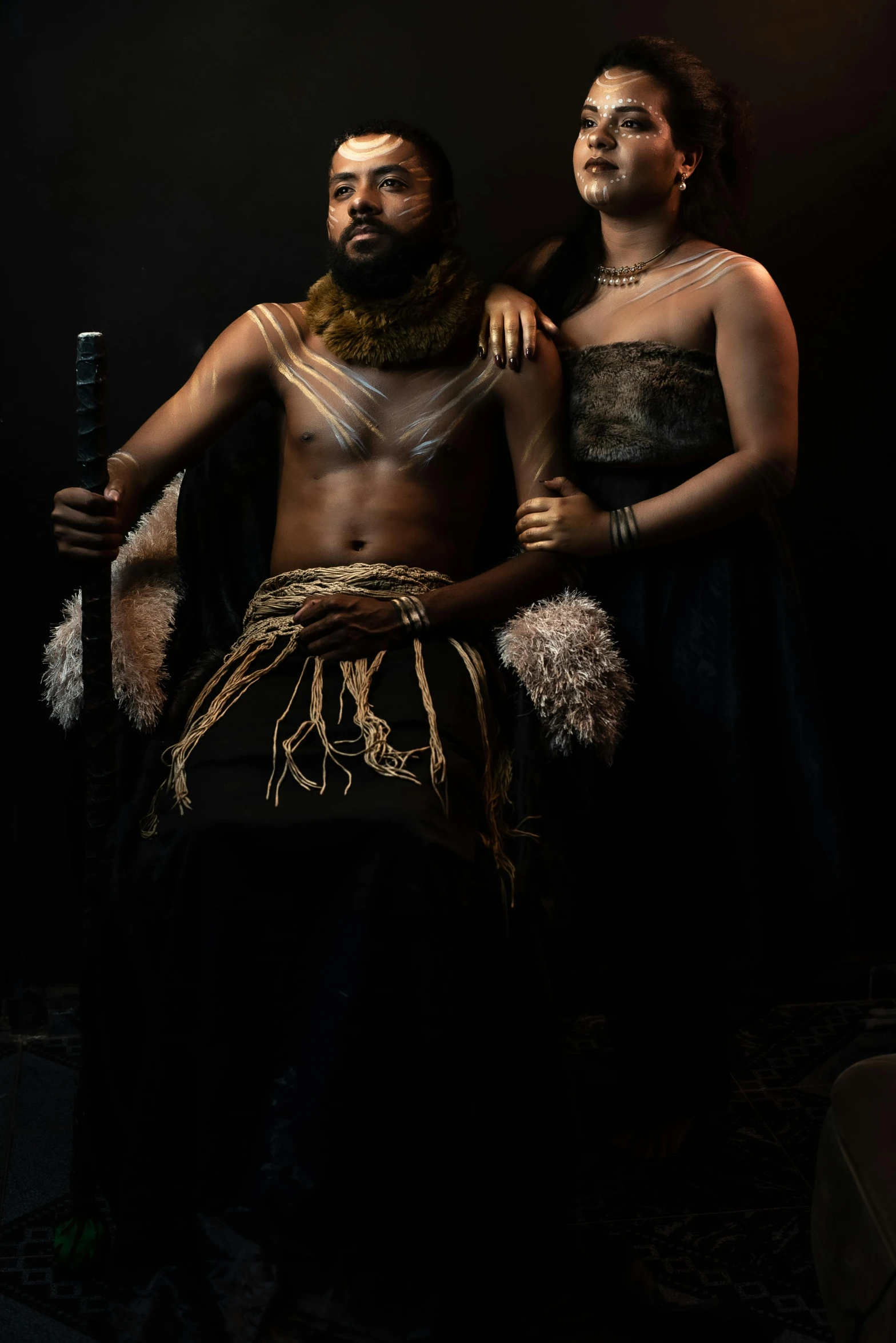 two african men are standing with one holding a sword