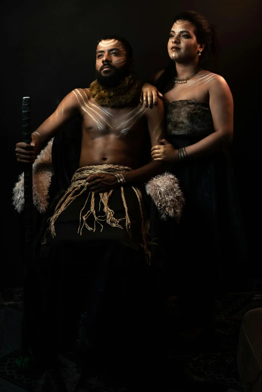 two african men are standing with one holding a sword