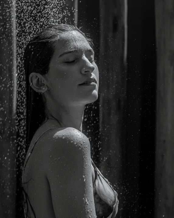 a woman is under a shower head in the shower