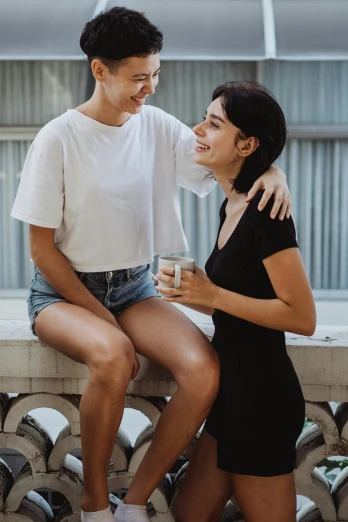 two young women sharing a laugh while standing in front of their shoes