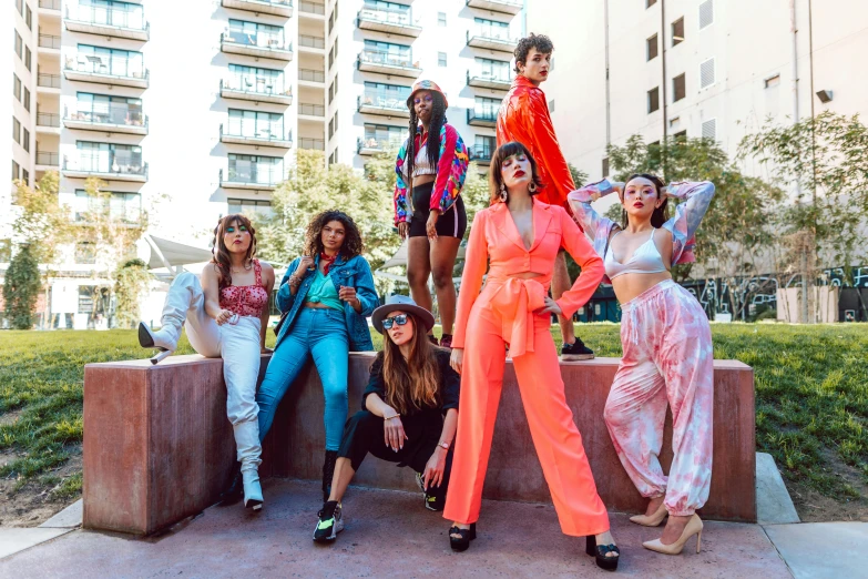 a group of women pose for a po in front of tall buildings