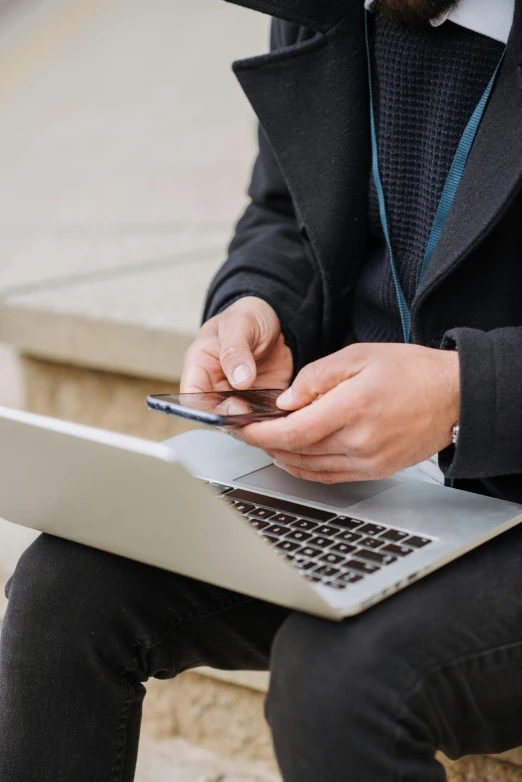 a person sitting on the ground using their cell phone