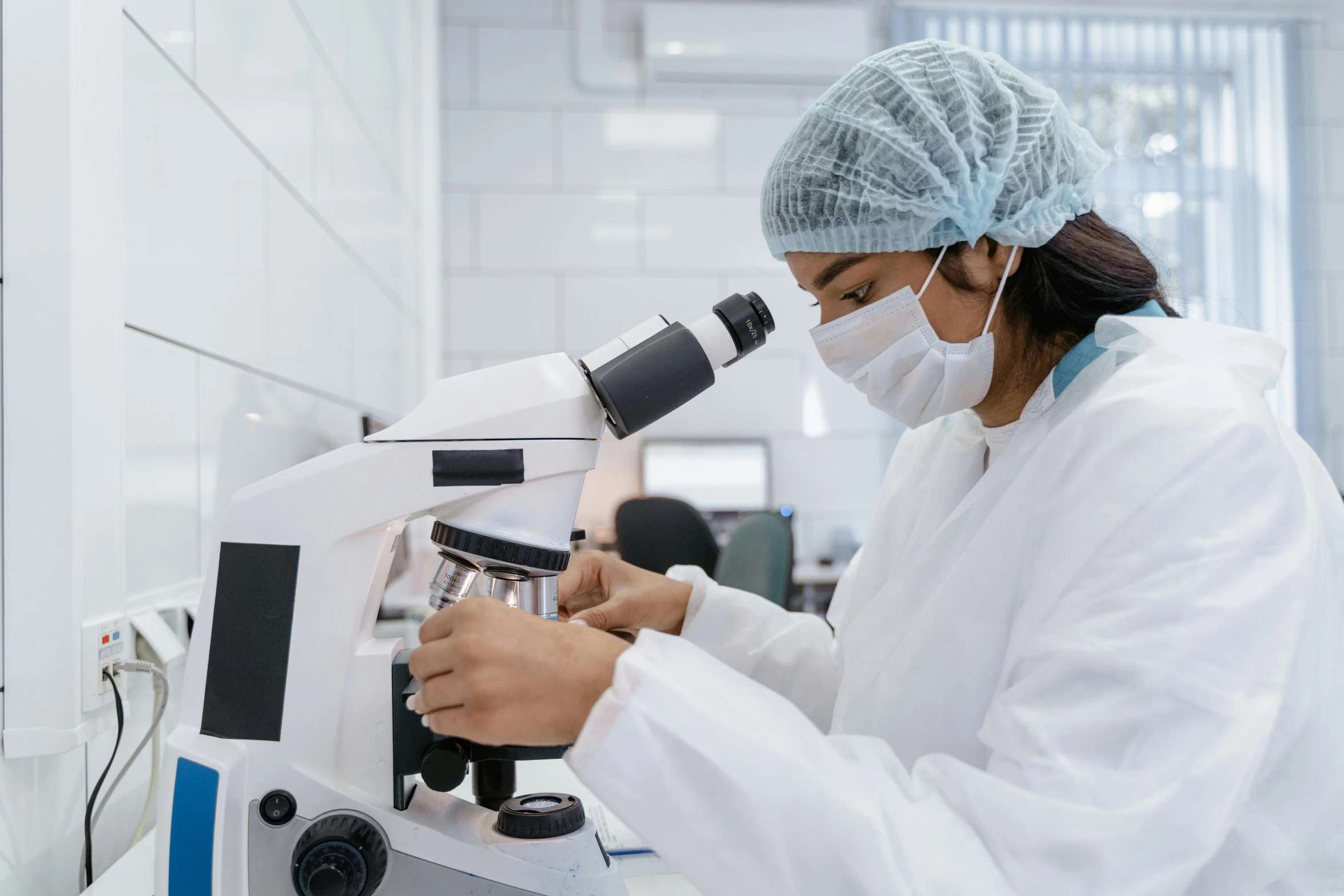 a laboratory worker looking into a microscope