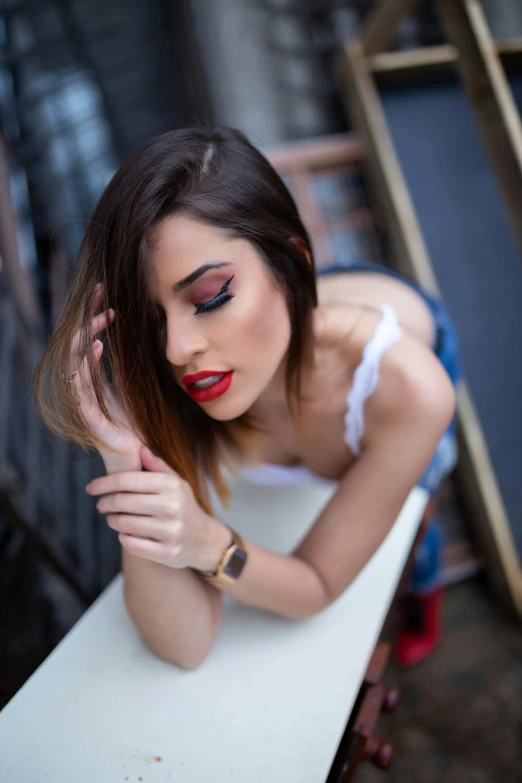 a girl with long dark hair sitting at a white table