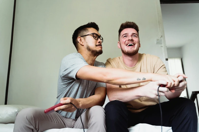 two men holding onto the handles of wii remotes