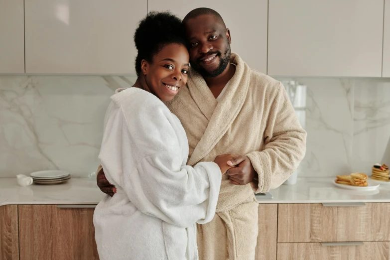 a black couple stand by a white and beige kitchen counter