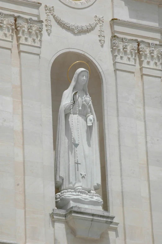 a statue of mary in front of the front door of a church