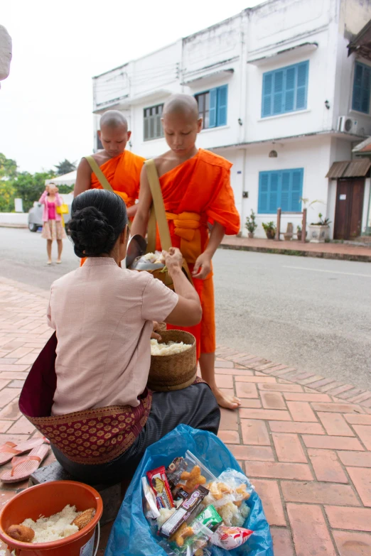 a monk is standing over two baskets of food