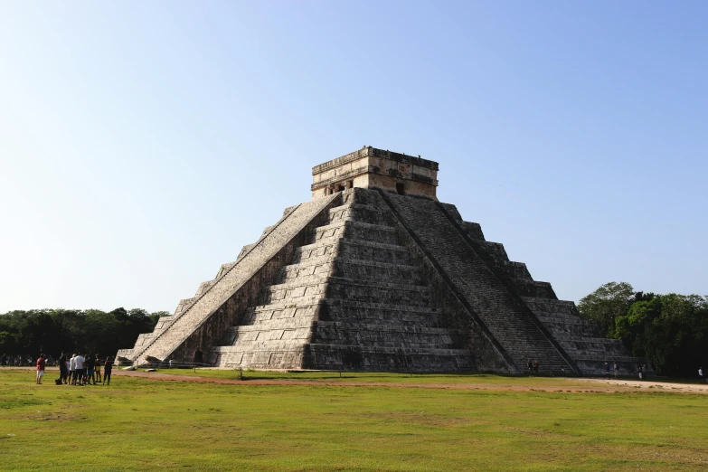 people standing in front of a pyramid type structure