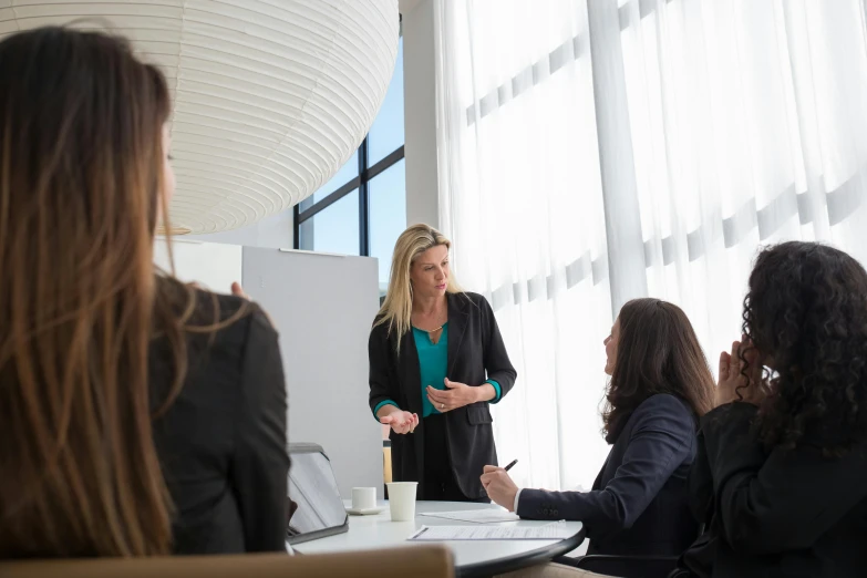 four women are in a meeting room having a discussion