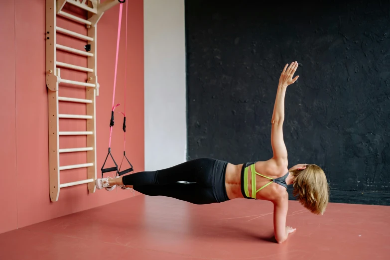 a woman practices the trx workout in a gym