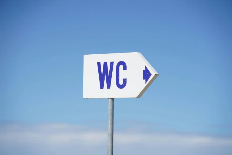 a white and blue directional sign sitting on the side of a road