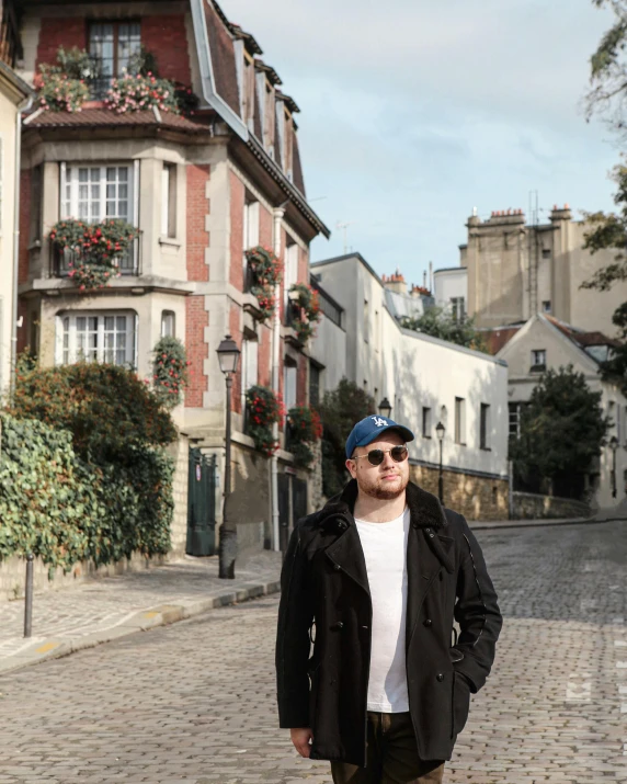 a man standing outside near some brick buildings