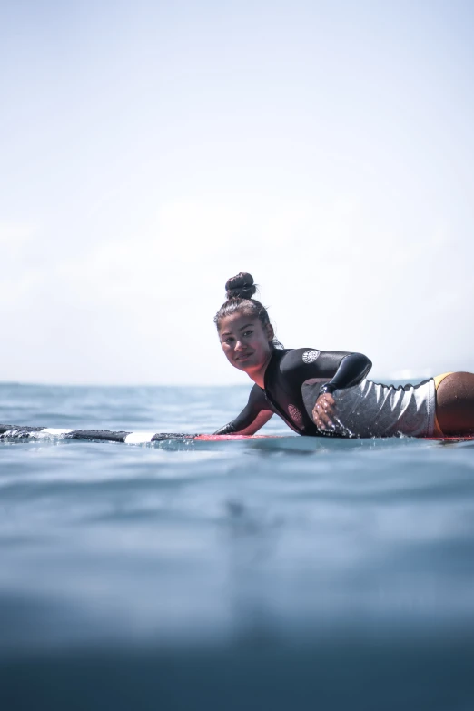 a woman laying on a surfboard in the ocean