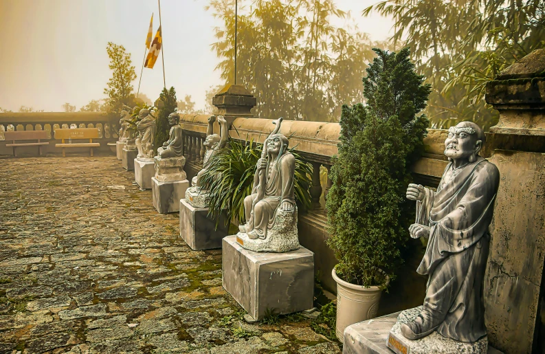 several statues of women in a row beside some bushes