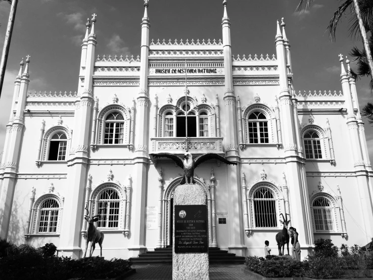 a man walks out front of a large white building