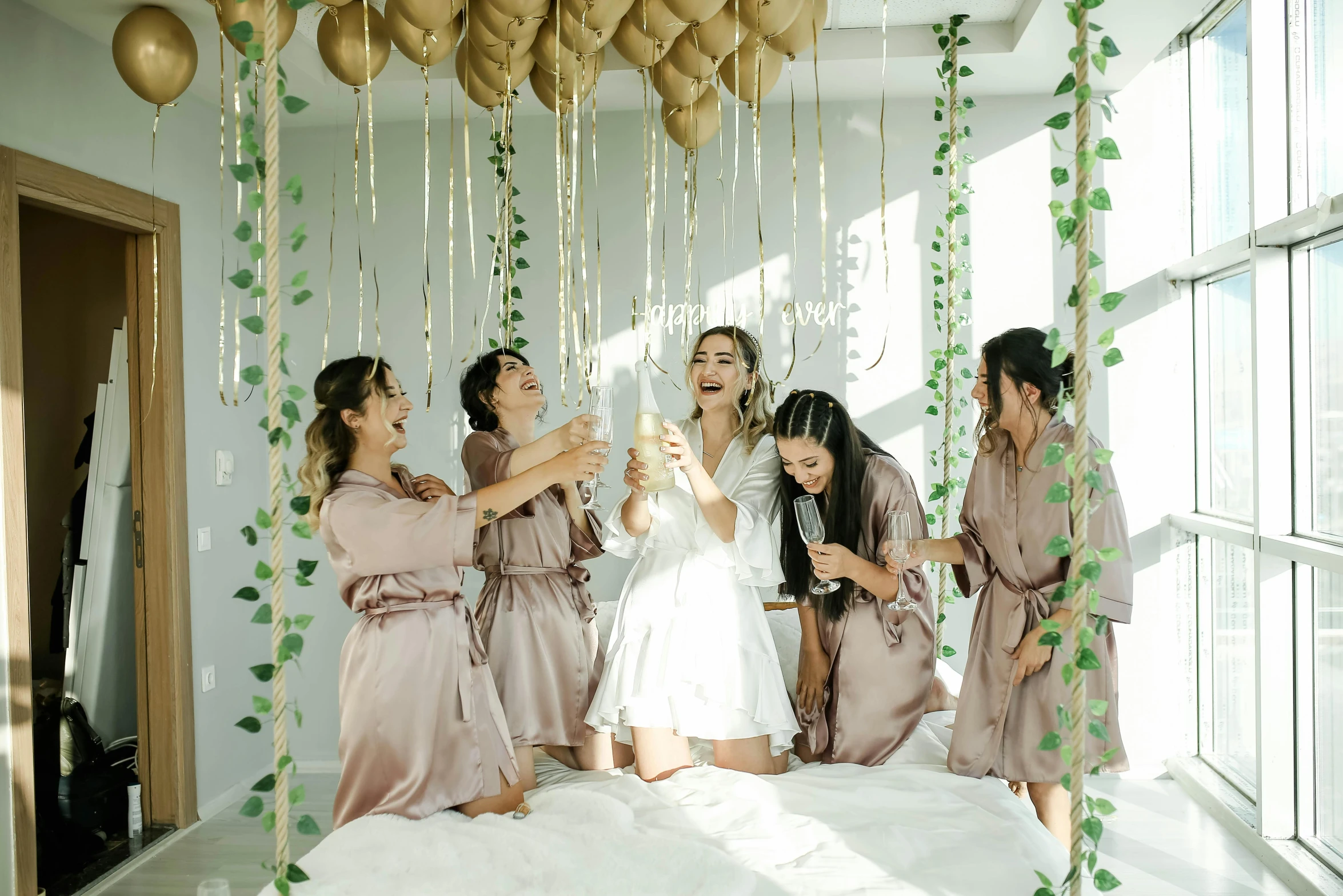 a group of women in gowns celeting with some gold balloons