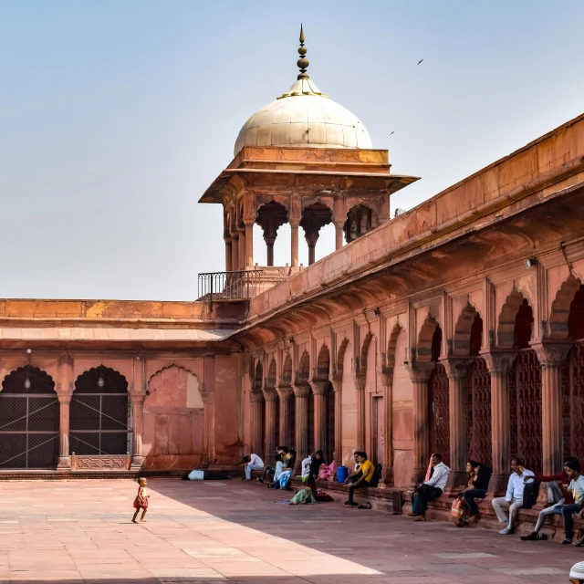 an arch leading to a building with lots of arches and walls