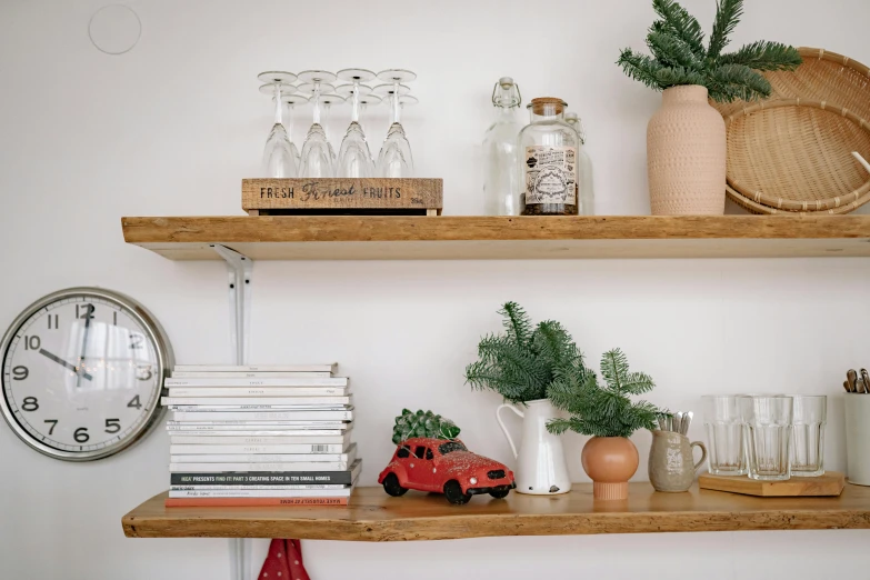 three shelves with plants, vases and a clock