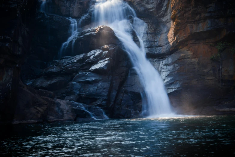 a tall waterfall coming from a cliff on the edge