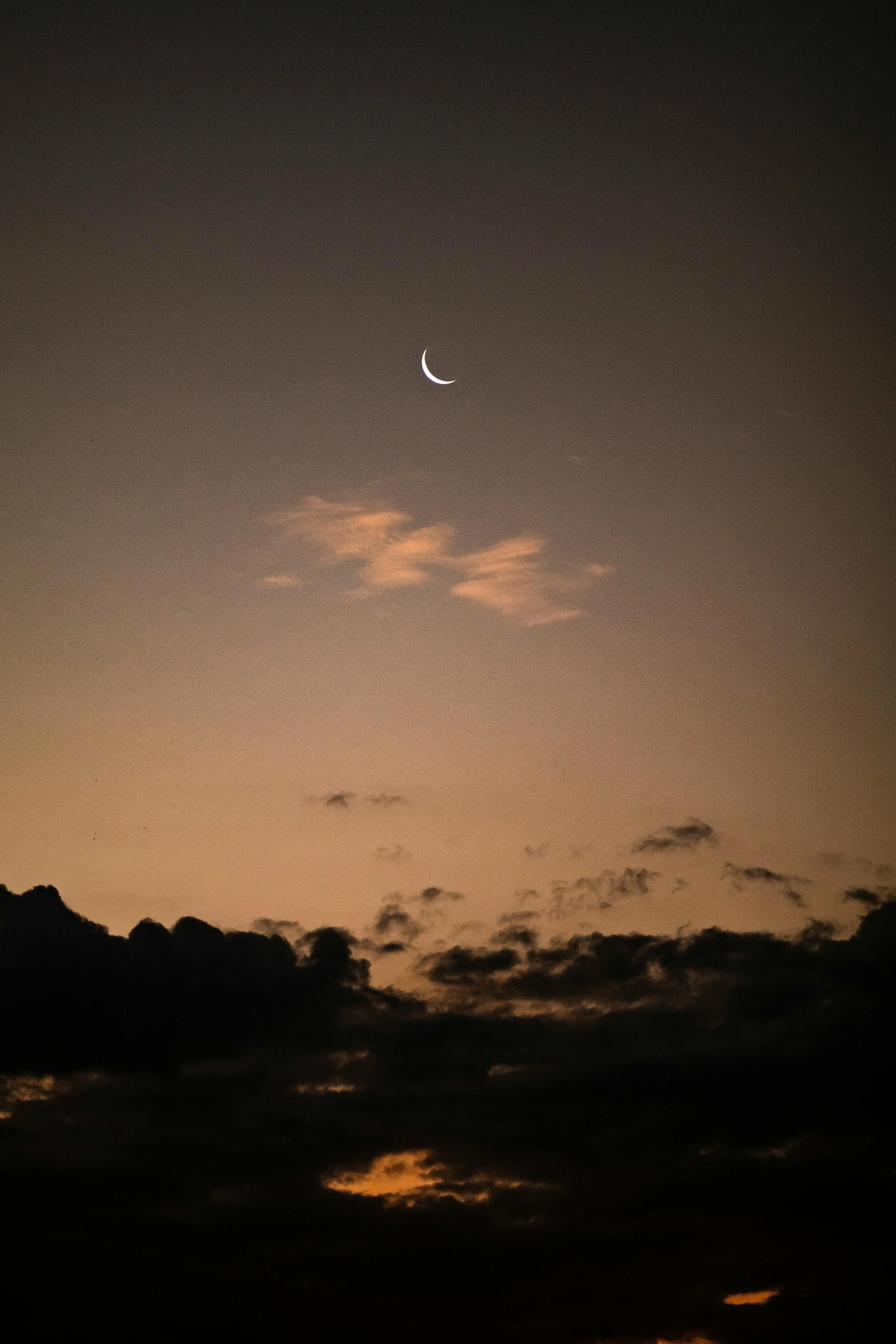 the moon is almost obscured by clouds at night