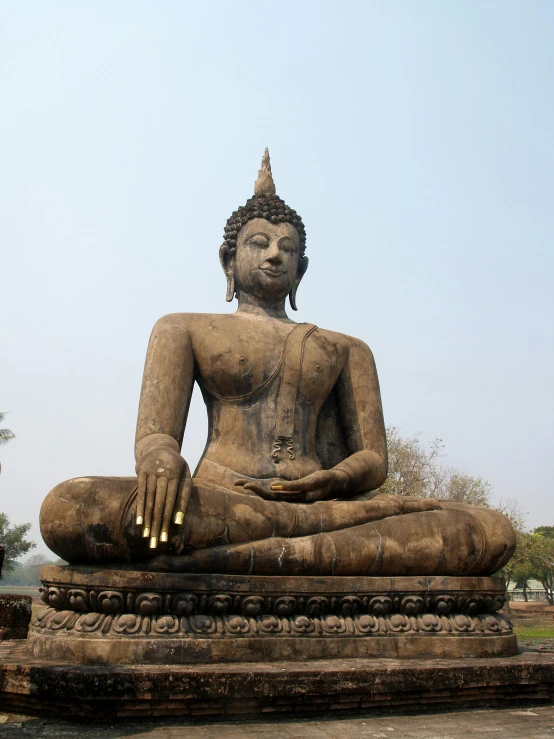 a large buddha statue sitting on top of a stone slab