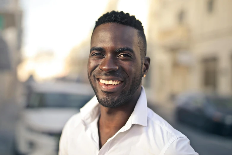 a man smiling wearing a white shirt