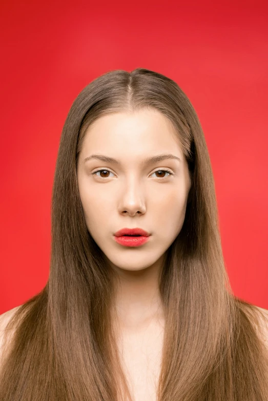woman with long hair and red lipstick in front of a bright background