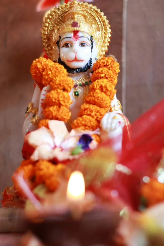 a small statue of lord ganeshh holding a lit candle