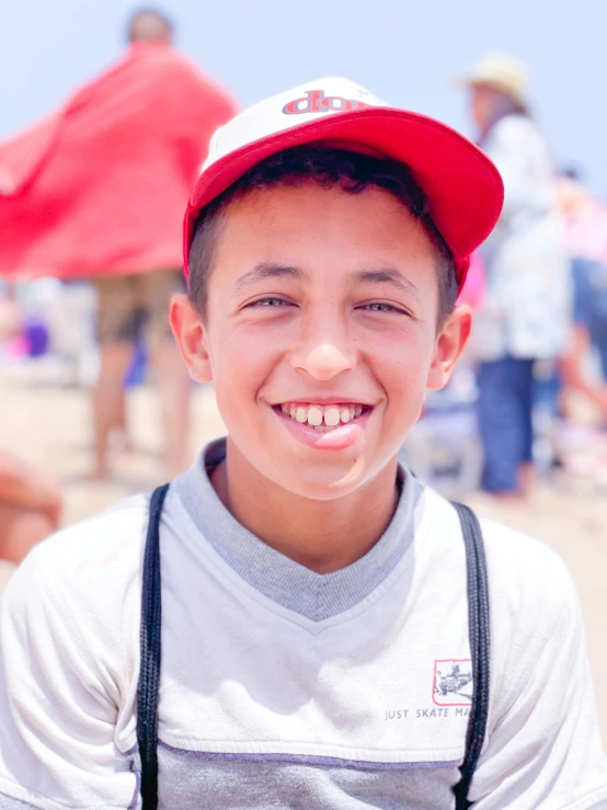 a boy in a red hat is smiling at the camera