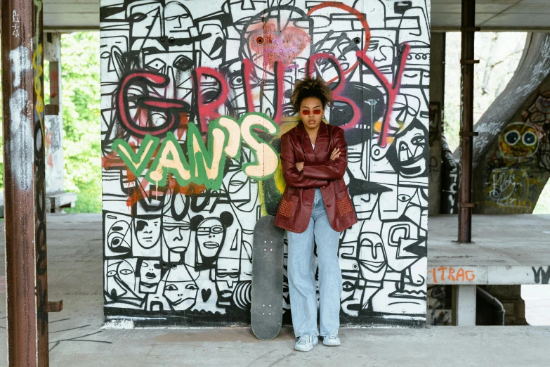 a woman standing in front of a wall with graffiti on it