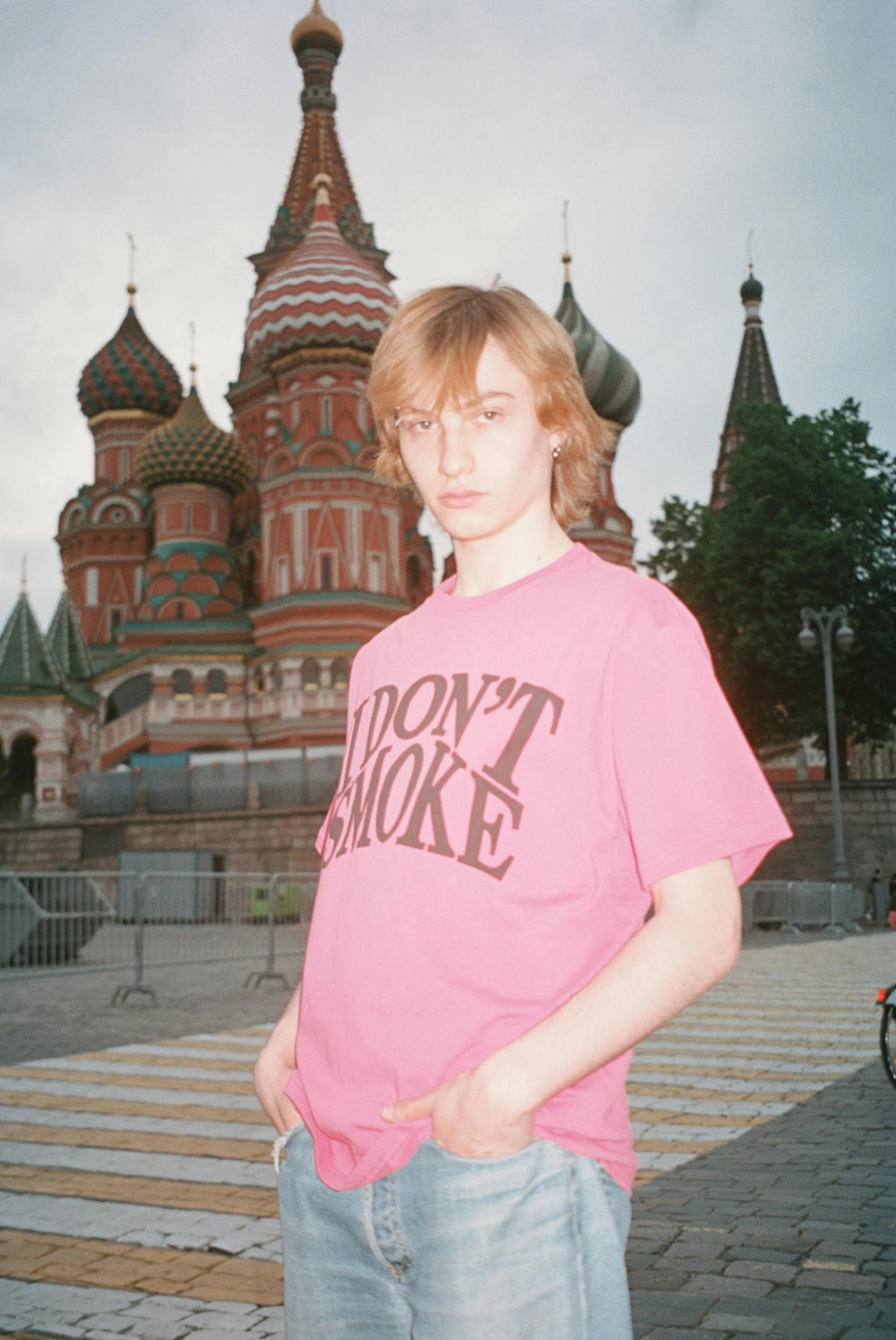 young man standing in front of an ornately painted castle