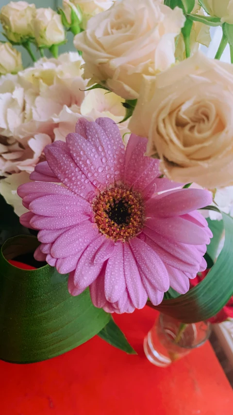 a glass vase holding an artificial flower arrangement