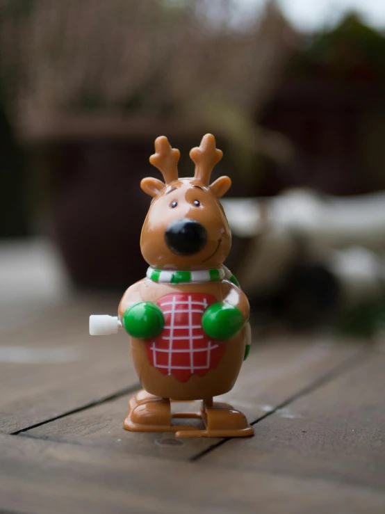 a toy reindeer holding an empty cup on a table