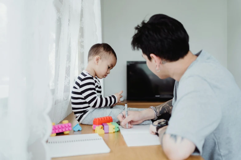 a boy and his father play on a desk