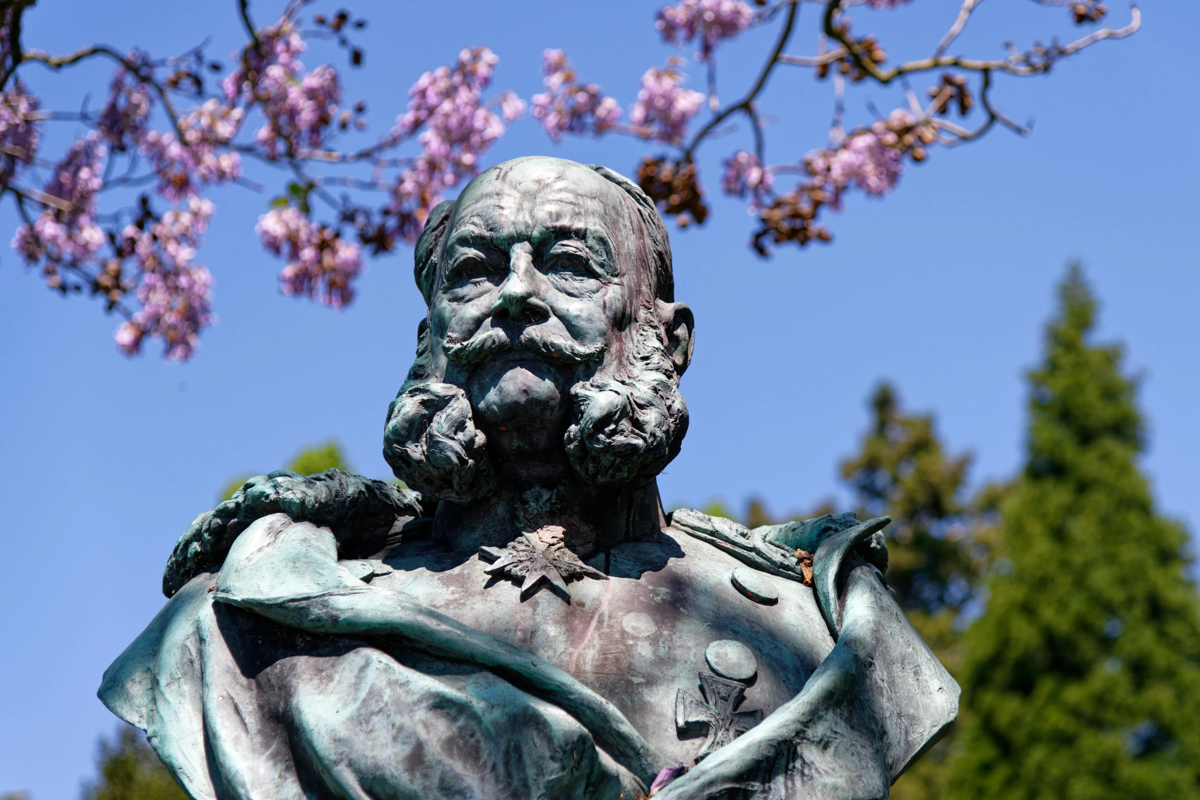 a statue is sitting in front of flowers