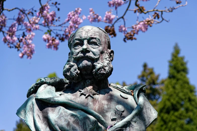 a statue is sitting in front of flowers