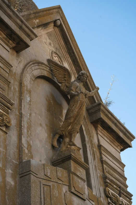 the top of an ornate, stone building with an angel on it