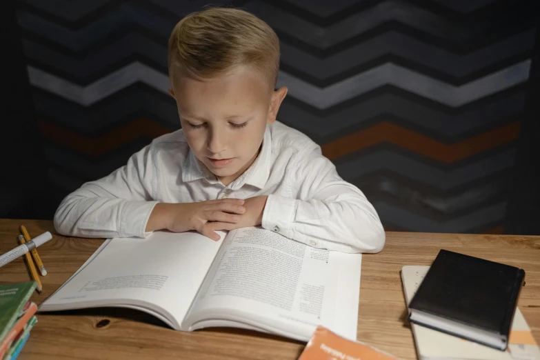 a  reading a book on top of a table