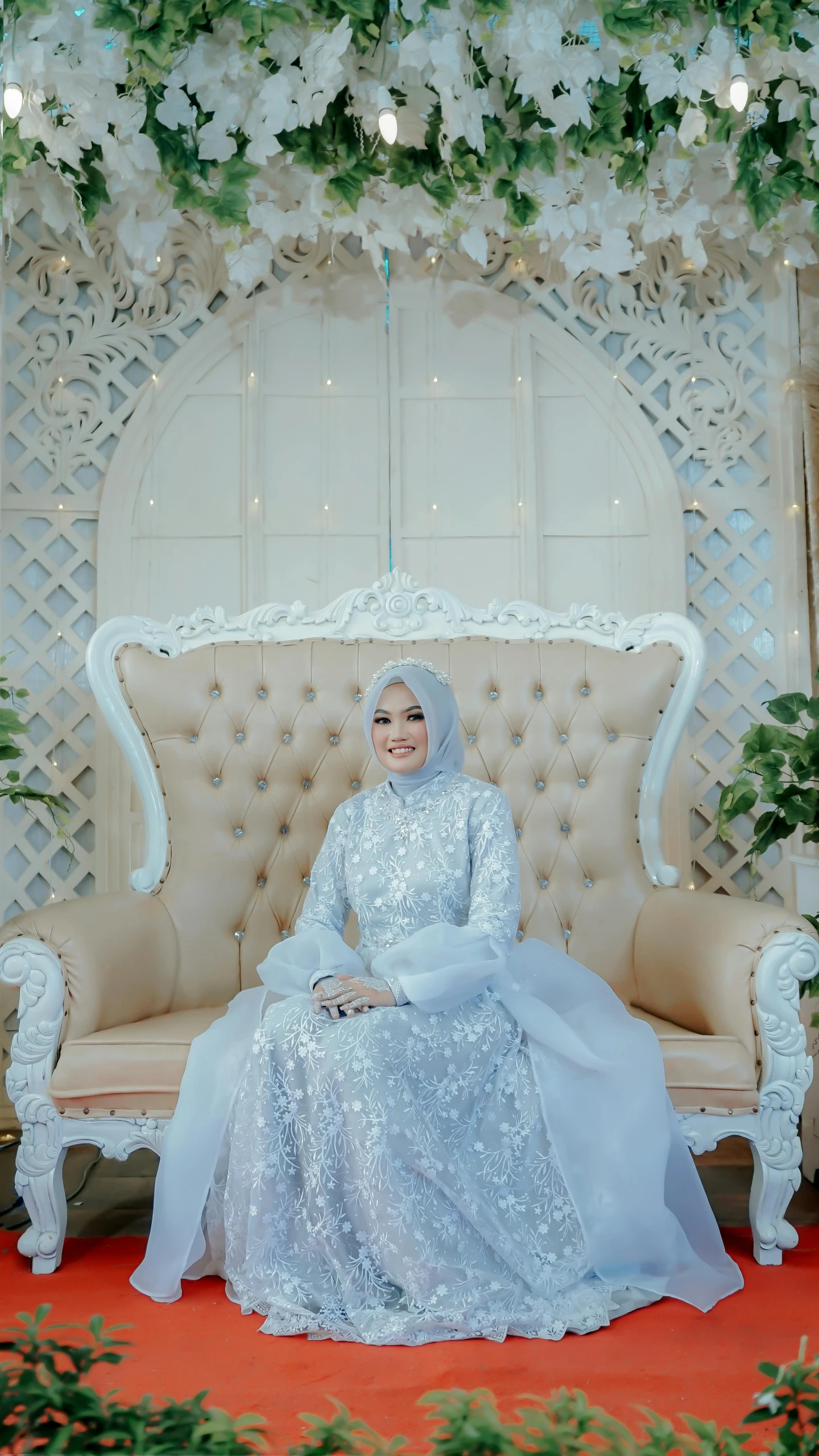 a bride in a white wedding gown sitting on a couch