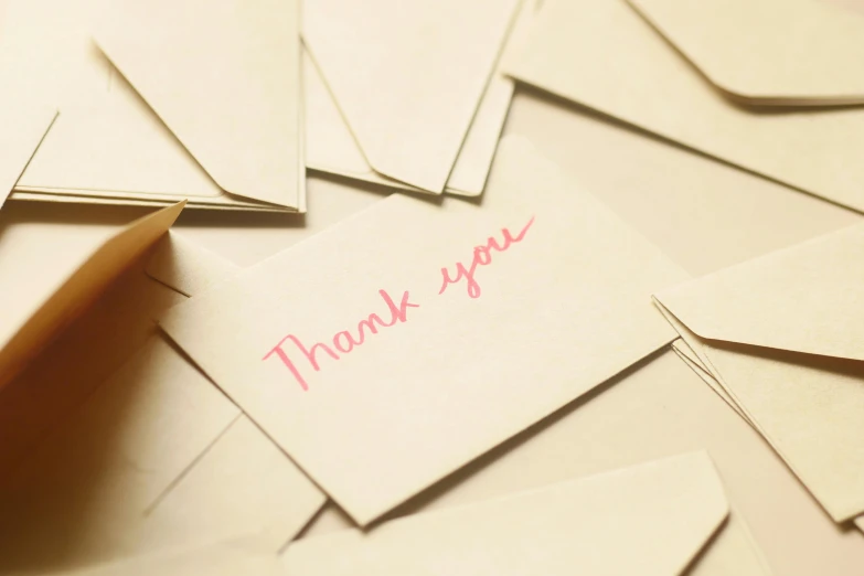 envelopes with thank you notes attached on top