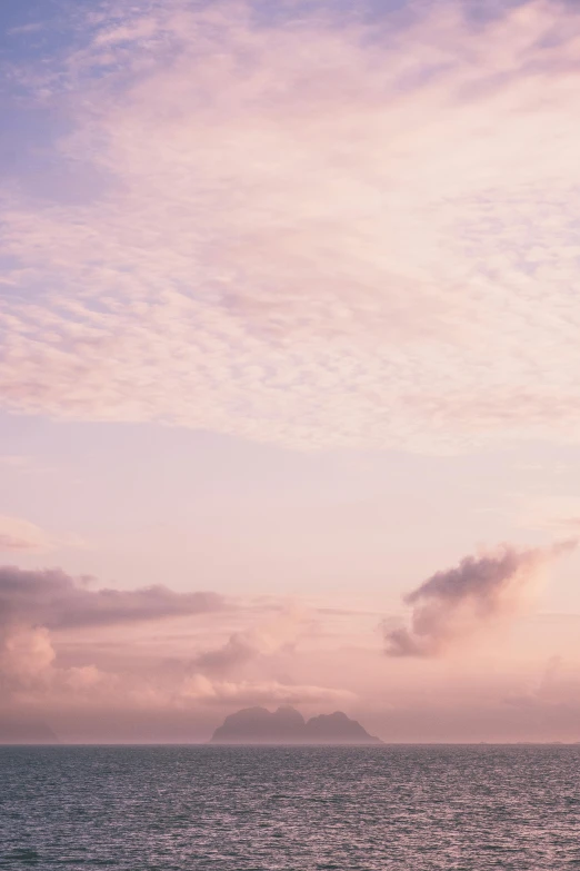 a pink and blue sky is on a calm ocean