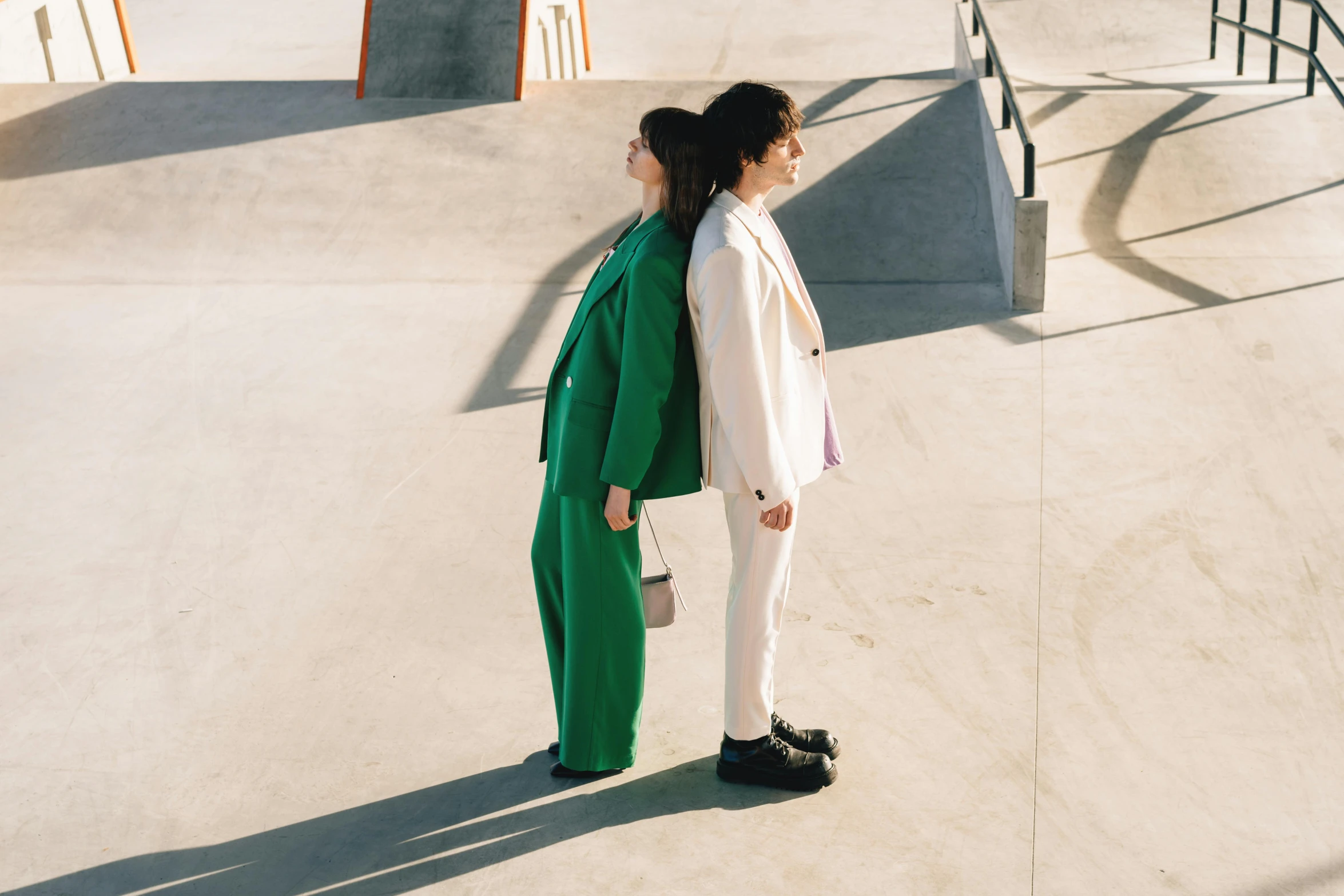 a woman in green stands alone on a skateboard ramp