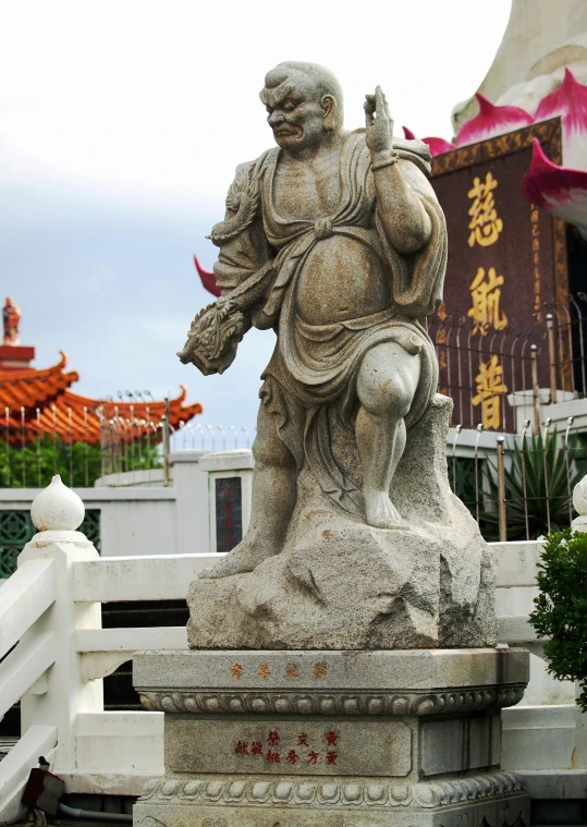 a statue of an elephant holding a bird on a platform