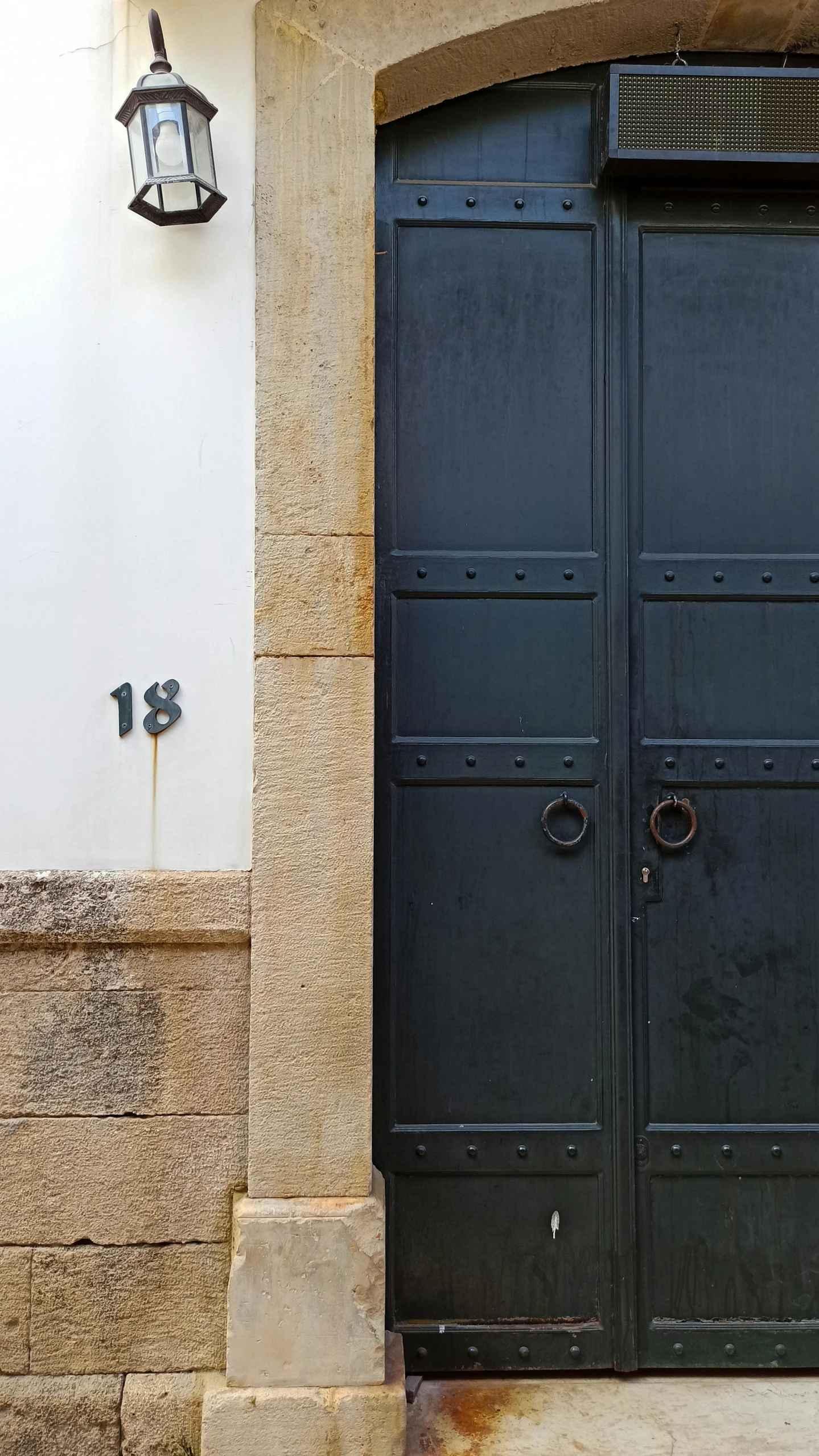 a black door is opened on an old building