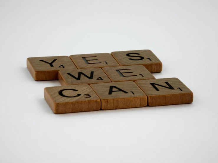 three wooden scrabbles with words spelling yes and no